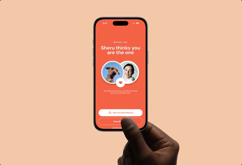 A hand holding a phone showing Sniff’s mutual-like screen, on a peach background